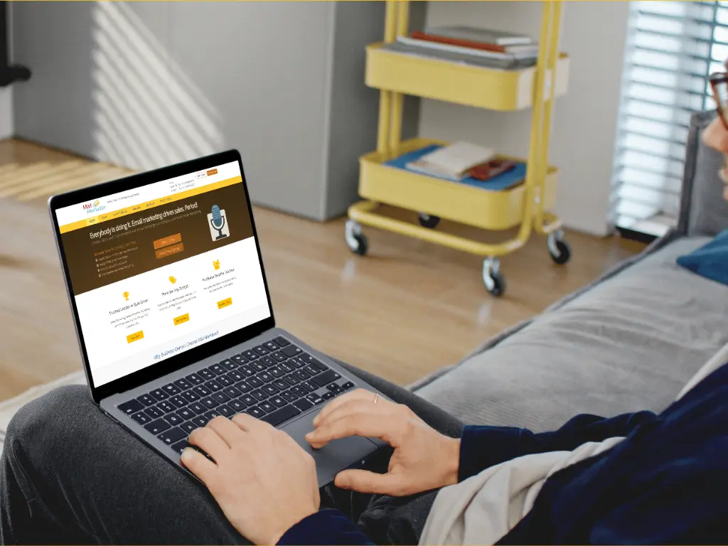 A professional marketer smiling while using the MailMarketer intuitive drag-and-drop editor interface to create an email campaign.
